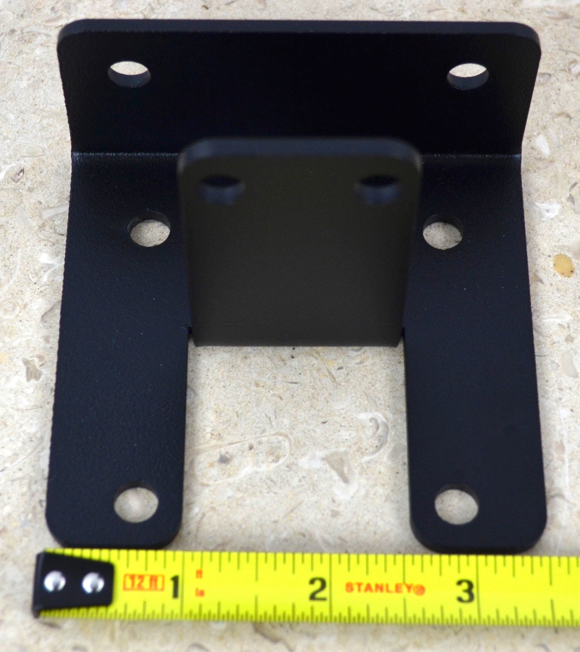 A black metal corner bracket is displayed, designed to provide support and stability in various construction applications. Ideal for DIY projects and repairs.