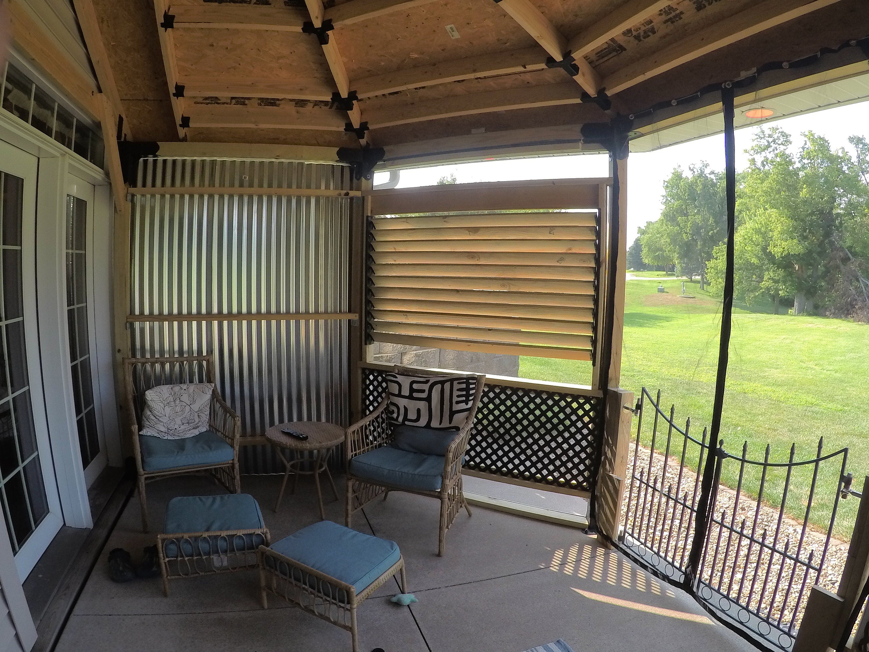 A cozy screened porch adorned with chairs and a table, perfect for enjoying the outdoors while being sheltered.