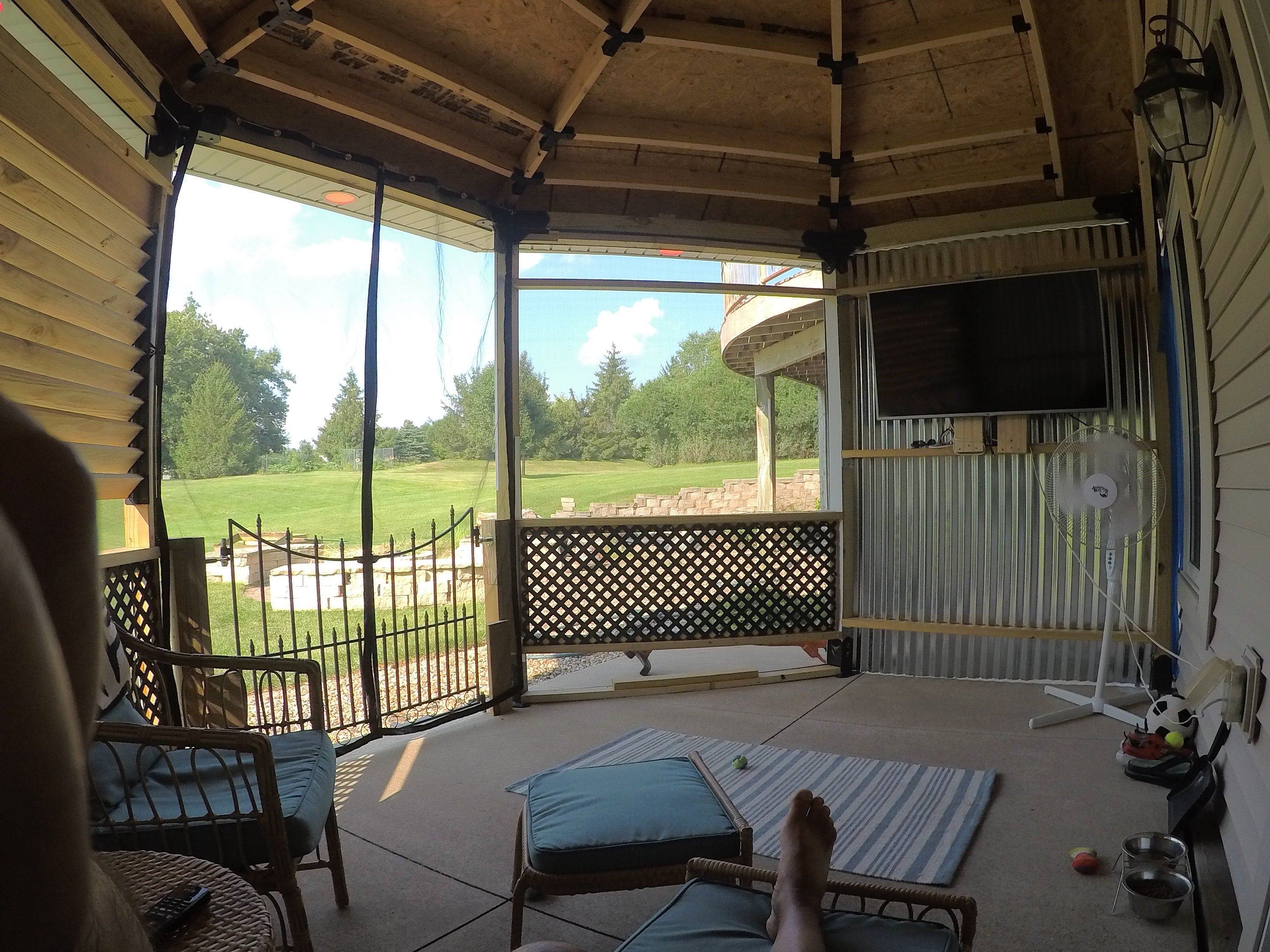 A cozy screened porch adorned with chairs and a table, perfect for enjoying the outdoors while being sheltered.