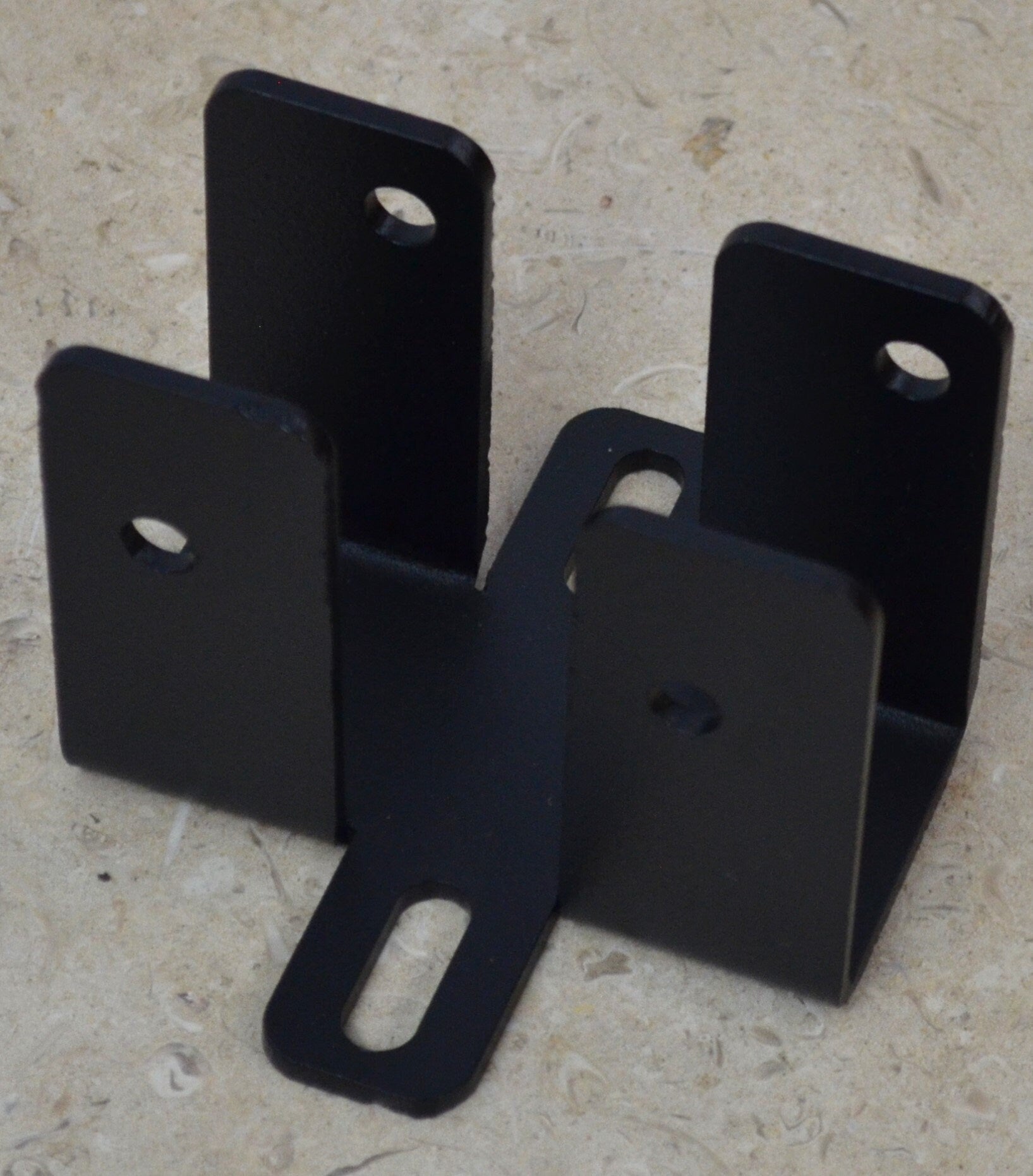 The black metal bracket features multiple holes for easy attachment and stability, making it ideal for construction, renovations, and DIY activities.