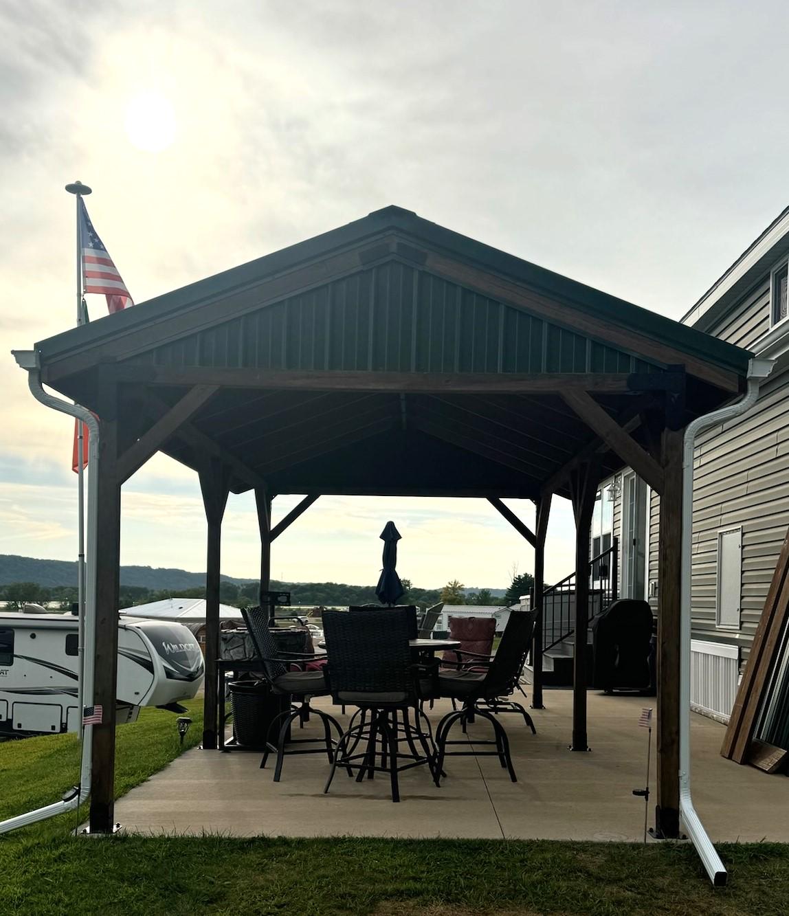 a wooden pavilion featuring a table and chairs, designed with a DIY 4X4 pavilion brackets kit for easy assembly.